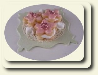 CDHM artisan Monica Cado Shellabarger creating under the business name of Bon Sucre Miniatures created this floral cake with a french accent for the dollhouse miniature collector in 1:12 scale