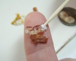 Putting glue on the back of the miniature bacon