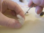 Needle punching the ear onto the teddy bears head