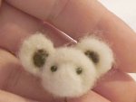 Completed two glass eyes embedded into the needle felted miniature teddy bear