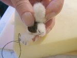 Making the final three claw stitches in the last leg of the miniature needle felted teddy bear