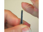 Twisting the remaining wire length together to make the legs of the miniature parrot