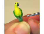 Painting the feet of the polymer clay miniature dollhouse parrot