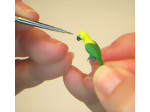 Painting the eyes of the conure clay parrot