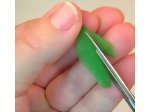 Trimming the right side of a feather to place on the polymer clay parrot
