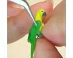 Repeat the gluing and add smaller primary-covert feathers to the other wing of the polymer clay parrot