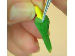 Remove excess feathers and glue with tweezers from your miniature parrot