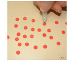Drawing a white line through the punched circles for dollhouse flowers