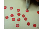 Drawing a crossed or 90 degree white line through the punched circles for dollhouse flowers